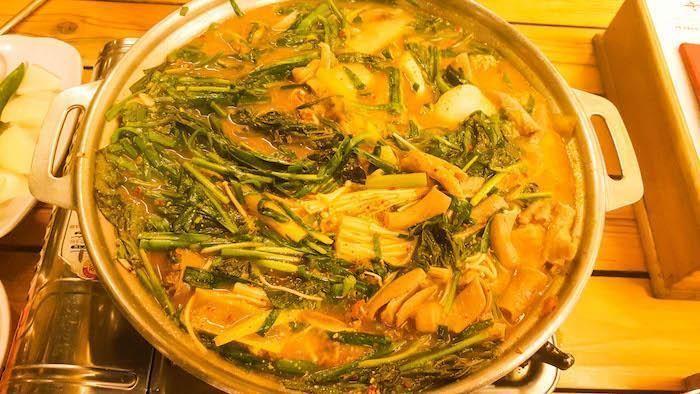 顺大实录中的嫩滑牛肉汤锅，满满的绿色蔬菜和香料。